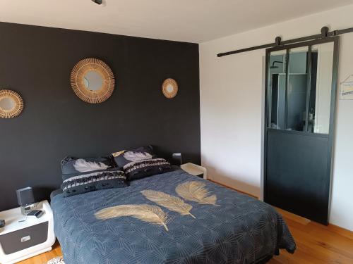 TonneinsL'Eden的一间卧室配有一张带羽毛的蓝色床。