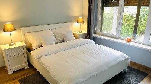 博茨科沃Pod Świerkami的卧室配有白色床和2扇窗户