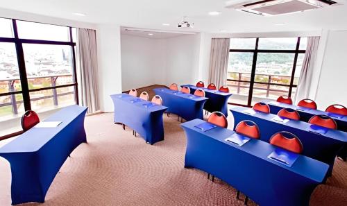 约恩维利约恩维利蓝树塔酒店的一间教室,配有蓝色和红色的椅子和窗户
