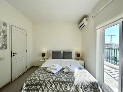奎特里拉Quarteira Ocean Breeze 1 With Pool by Homing的一间卧室配有一张床,上面有两条毛巾