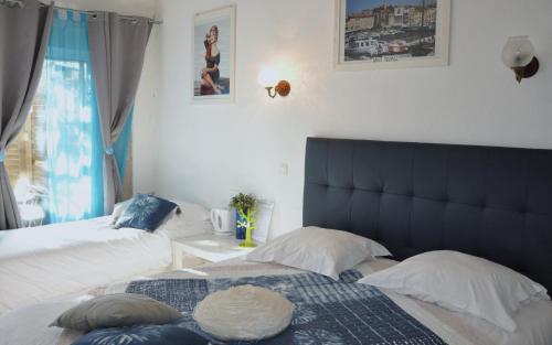 博尔马斯·莱斯·米默萨斯莱斯米默萨斯酒店的一间卧室设有两张床和蓝色床头板