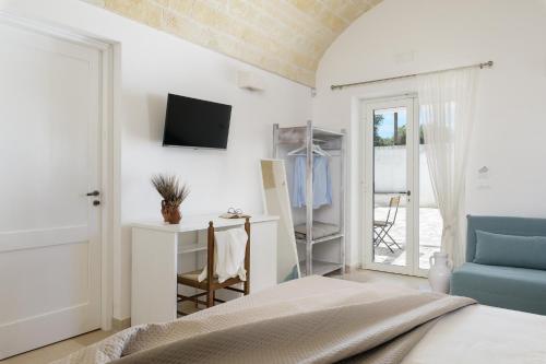 奥斯图尼Masseria Abadia Uno的一间卧室配有一张床,墙上配有电视