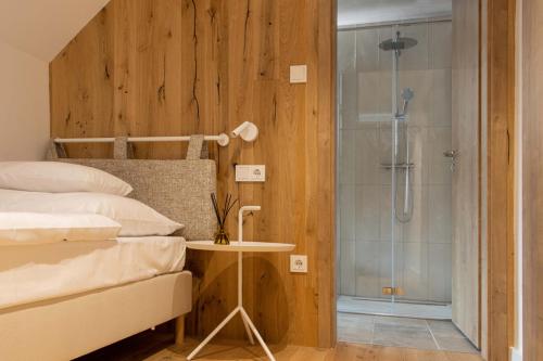 让贝克Hegyalja Étterem és Panzió的一间卧室设有一张床和一个玻璃淋浴间