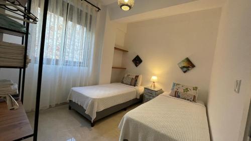 卡斯Ozy Apart Garden / Kaş-Çerçiler的一间卧室设有两张床和窗户。
