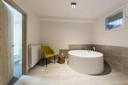 宏达瑞比亚Hotel Onyarbi的浴室设有白色浴缸和黄色椅子