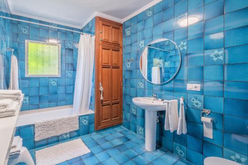 阿尔盖达Villa Son Bibiloni的蓝色瓷砖浴室设有水槽和镜子