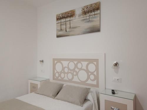 奇皮奥纳洛斯阿科斯旅舍的白色卧室配有一张带两张桌子的床