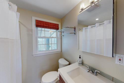 西雅茅斯Downtown Beach Cottage的一间带水槽和卫生间的浴室以及窗户。