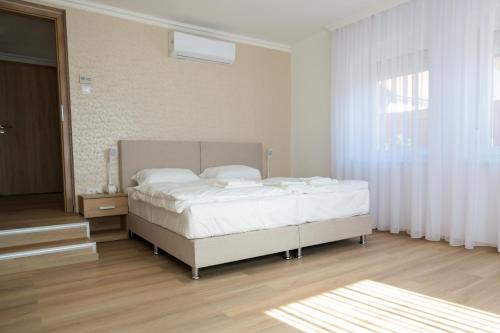 小克勒什Markó Vendégház的卧室配有白色的床和窗户。