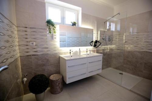 小克勒什Markó Vendégház的浴室配有白色水槽和淋浴。