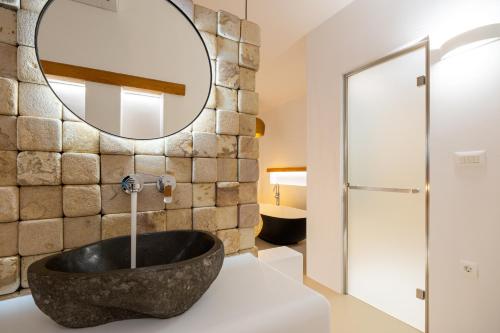 阿吉亚艾里尼帕罗Utopia Suites by Anna Platanou的一间带大型石质水槽和镜子的浴室