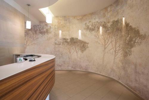 福洛尼卡拉毕内塔酒店的厨房墙上挂有树木壁画