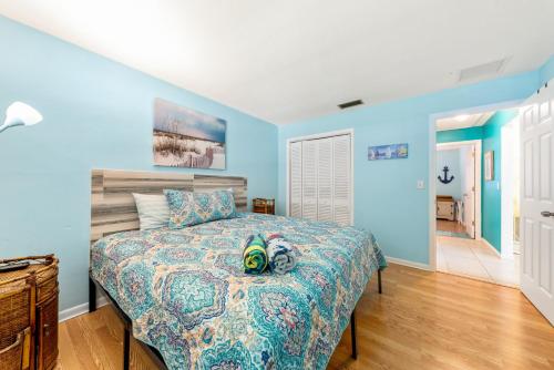 克利尔沃特Beach Villa A的一间卧室配有一张蓝色墙壁和木地板。
