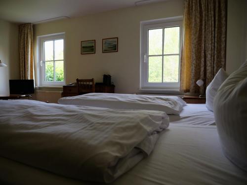 诺因多夫Hotel Heiderose Hiddensee的卧室设有两张床,带两个窗户