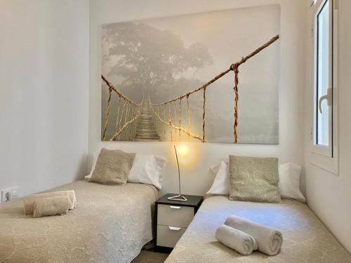 巴塞罗那2 BDR EIXAMPLE APARTMENT的墙上挂着桥画的房间里,有两张床