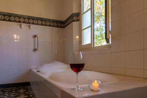 普尔马马尔卡埃尔曼娜提尔德尔锡伦西奥酒店的坐在带蜡烛的浴缸上喝一杯葡萄酒