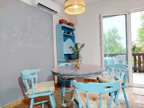 包道乔尼托毛伊HangVilla Badacsony的一间配备有蓝色桌子和椅子的用餐室