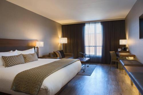 堪萨斯城AC Hotel Kansas City Plaza的酒店客房设有一张大床和一张书桌。