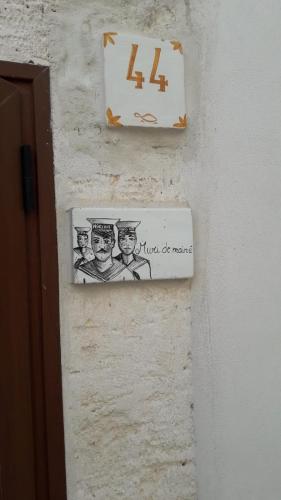 奥斯图尼Muri de mainè的墙上的标牌上写着三位男子的照片