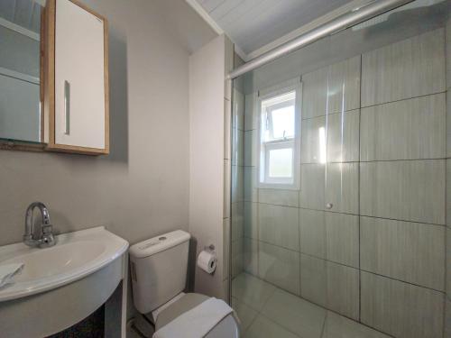 格拉玛多Pousada Boschetti的浴室配有卫生间、盥洗盆和淋浴。