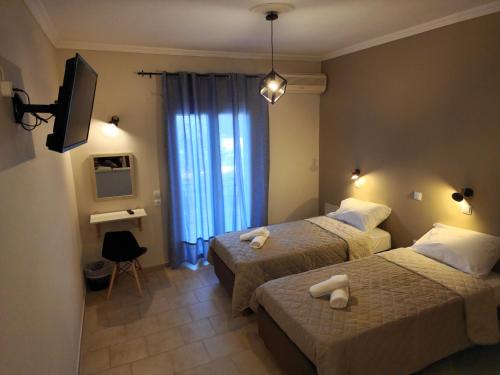 卡沃斯Cavo Garden的酒店客房设有两张床和电视。