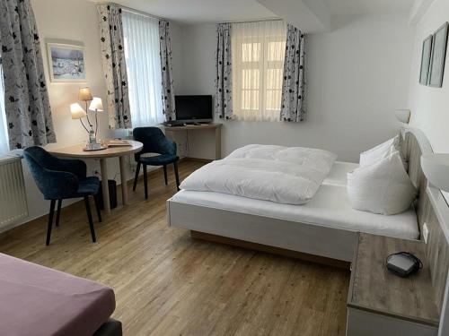 希斯利兹Hotel Gasthof Krapp的一间卧室配有一张床和一张桌子及椅子