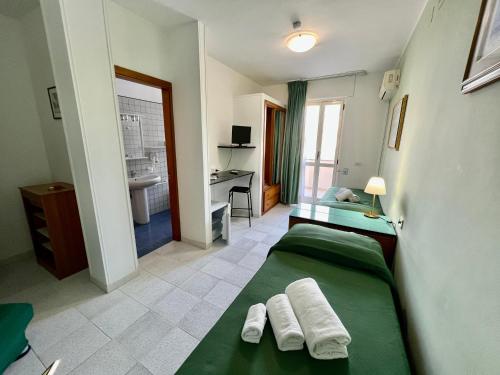 奥特朗托Hotel Minerva的一间卧室配有两张绿色的床和一张书桌