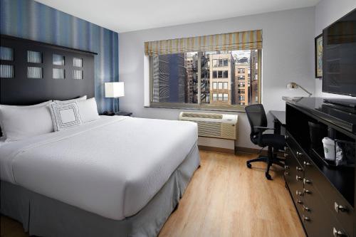 纽约纽约曼哈顿/切尔西万豪费尔菲尔德酒店的配有一张床、一张书桌和一扇窗户的酒店客房
