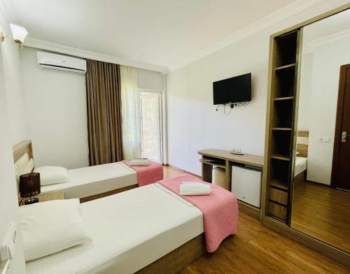 谢赫维蒂利Sea Line Hotel的酒店客房设有两张床和电视。
