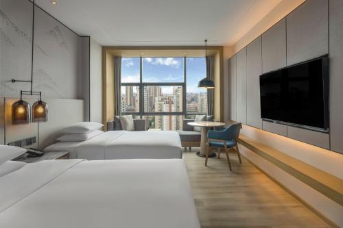 佛山佛山高明联塑万怡酒店的酒店客房设有两张床和一台平面电视。