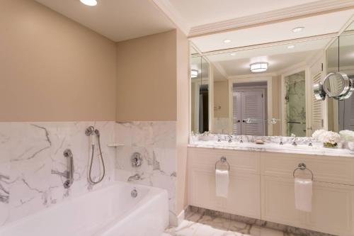 那不勒斯The Ritz-Carlton Naples, Tiburon的一间带浴缸和大镜子的浴室