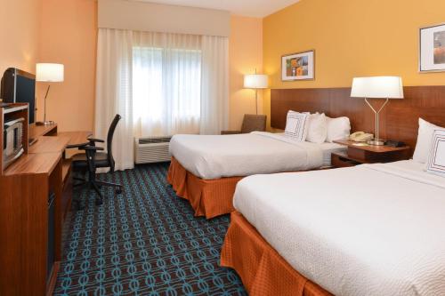 橘园杰克逊橙园费尔菲尔德客栈的酒店客房配有两张床和一张书桌