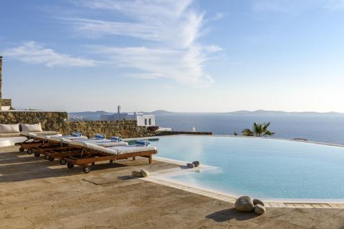 图罗斯Villa Yasmina的一个带躺椅的游泳池,背景是大海
