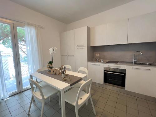 里乔内Residenza Clelia Riccione的厨房配有桌椅和水槽。