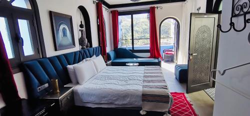 舍夫沙万Riad El Palacio & Spa Chaouen的一间卧室,配有一张床铺和一张火车上的椅子