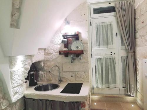 马丁纳弗兰卡Archetto Bianco的一个带水槽和窗户的小厨房