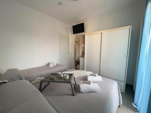 里乔内Residenza Clelia Riccione的客厅配有两张床和一张桌子