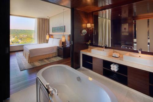 浦那浦那JW万豪酒店的带浴缸的浴室和1间带1张床的卧室