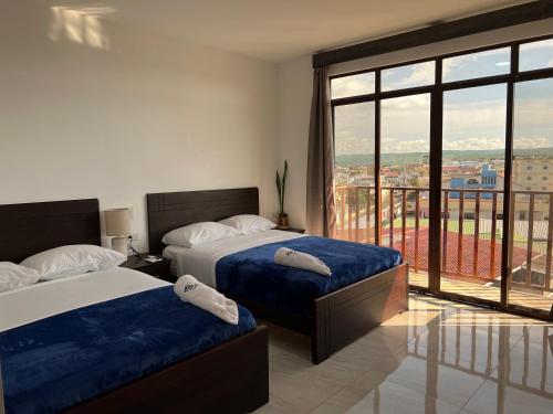 曼塔Katamar的一间卧室设有两张床和大窗户
