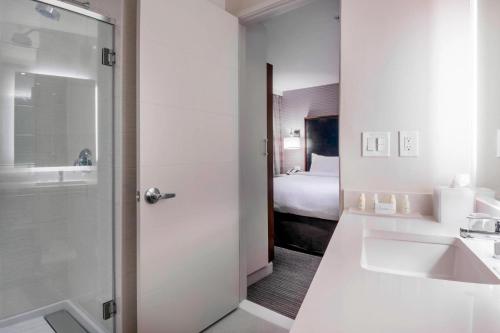 泽西市泽西市原住客栈酒店的一间带水槽的浴室和一间配有床铺的浴室