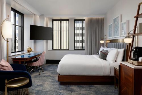 明尼阿波利斯Rand Tower Hotel, Minneapolis, a Tribute Portfolio Hotel的配有一张床和一张书桌的酒店客房