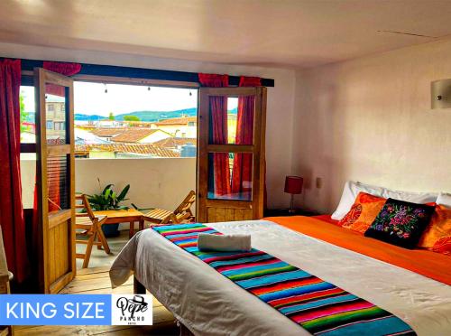 圣克里斯托瓦尔-德拉斯卡萨斯Hotel Pepe Pancho的一间带一张特大号床的卧室和一个阳台
