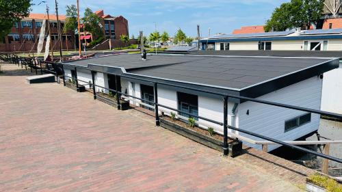 哈尔德韦克Woonboot 4 Harderwijk的一条白色的街道上,有黑色屋顶