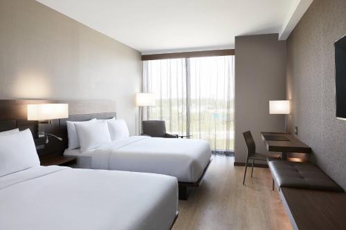 明尼阿波利斯AC Hotel by Marriott Minneapolis West End的酒店客房设有两张床和窗户。