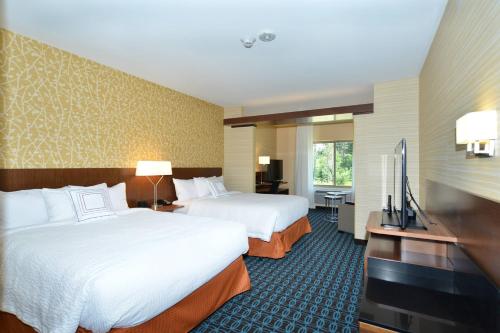 欧克莱尔欧克雷尔/奇珀瓦福尔斯费尔菲尔德客栈及套房的酒店客房设有两张床和一台平面电视。