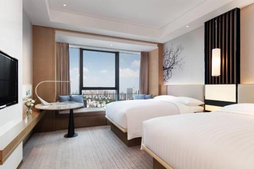 长沙长沙中建万怡酒店的酒店客房设有两张床和电视。