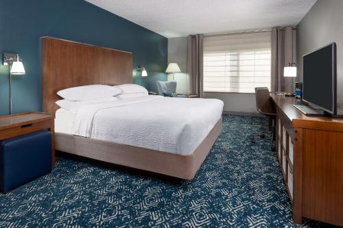 麦迪逊福朋亨茨维尔机场酒店的配有一张床和一台平面电视的酒店客房