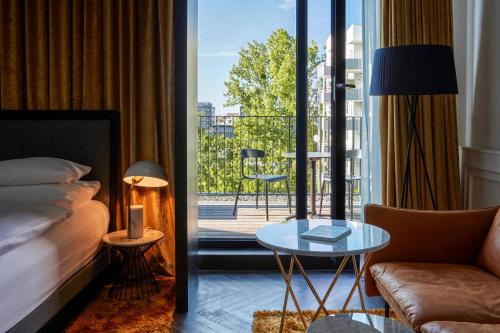 慕尼黑慕尼黑房客酒店 - 傲途格精选酒店的酒店客房设有一张床,享有阳台的景色