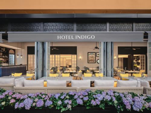深圳深圳威尼斯英迪格酒店的酒店大堂设有长沙发、桌子和鲜花