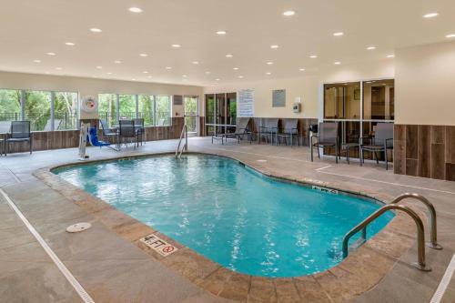 海伦Fairfield Inn & Suites by Marriott Helen的酒店大堂的游泳池,配有桌椅